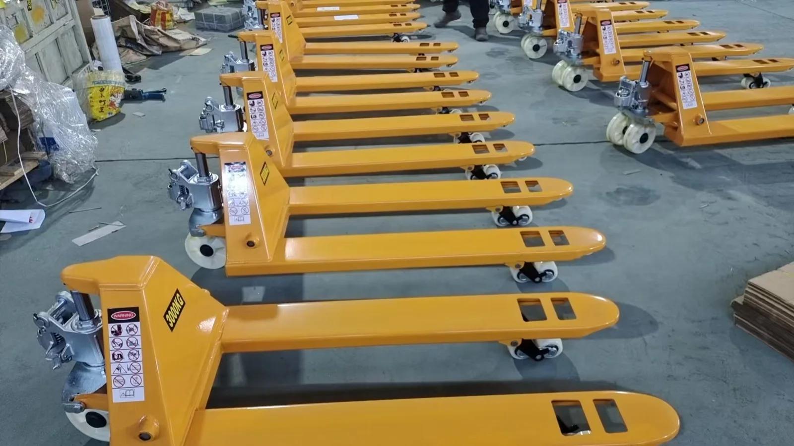 Yellow hand pallet trucks arranged in batches